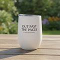 tumbler in a garden on an outdoor table with the phrase "out past the pages/life beckons"